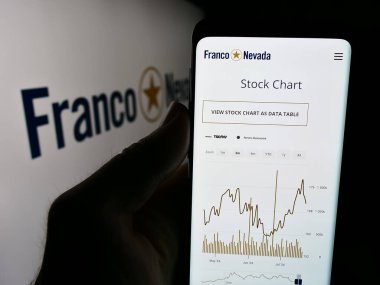 Stuttgart, Almanya - 07-19-2024: Kanadalı altın akışı şirketi Franco-Nevada Corporation 'ın logolu web sayfası ile cep telefonu tutan kişi. Telefon ekranının merkezine odaklan.