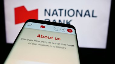 Stuttgart, Almanya - 07-19-2024: Logo önünde Kanada Ulusal Bankası (NBC) finans hizmetleri şirketinin web sitesi ile cep telefonu. Telefon ekranının sol üst kısmına odaklan.