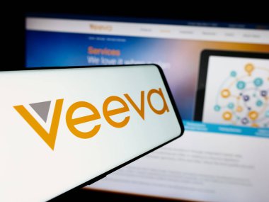 Stuttgart, Germany - 07-19-2024: Smartphone with logo of American software company Veeva Systems Inc. in front of business website. Focus on center-left of phone display. clipart