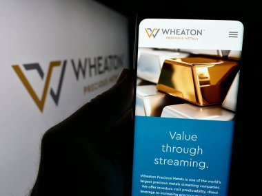Stuttgart, Almanya - 07-19-2024: Kanadalı metal şirketi Wheaton Precious Metals Corp 'un logolu web sitesi ile akıllı telefon sahibi kişi. Telefon ekranının merkezine odaklan.