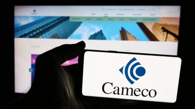 Stuttgart, Almanya - 07-21-2024: Kanadalı uranyum madencilik şirketi Cameco Corporation 'ın logosuna sahip akıllı telefon sahibi kişi web sitesi önünde. Telefon ekranına odaklan.