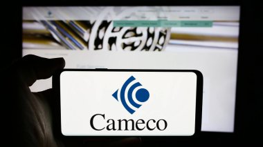 Stuttgart, Almanya - 07-21-2024: Kanada 'lı uranyum madencilik şirketi Cameco Corporation' ın logosunun bulunduğu cep telefonu sahibi kişi iş sayfası önünde. Telefon ekranına odaklan.