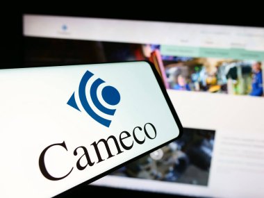 Stuttgart, Germany - 07-21-2024: Mobile phone with logo of Canadian uranium mining company Cameco Corporation in front of business website. Focus on center of phone display. clipart