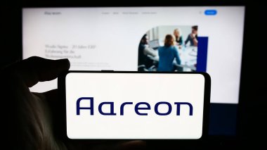 Stuttgart, Almanya - 07-21-2024: Alman emlak yazılım şirketi Aareon AG 'nin logosuyla cep telefonu sahibi kişi iş sayfasının önünde. Telefon ekranına odaklan.