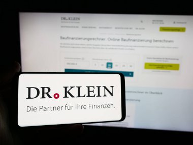 Stuttgart, Almanya - 07-21-2024: İnternet sitesi önünde Alman finans danışmanlık şirketi Dr. Klein Co. AG 'nin logosuna sahip kişi. Telefon ekranına odaklan.
