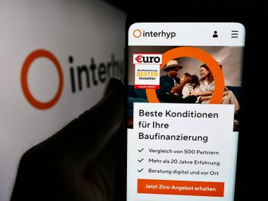 Stuttgart, Almanya - 07-21-2024: Logo önünde Alman ipotek komisyoncusu Interhyp AG 'nin web sayfası ile cep telefonu tutan kişi. Telefon ekranının merkezine odaklan.