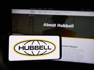 Stuttgart, Almanya - 07-21-2024: ABD 'li elektronik şirketi Hubbell Anonim Şirketi' nin logosuna sahip akıllı telefon sahibi kişi web sitesi önünde. Telefon ekranına odaklan.
