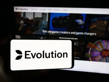 Stuttgart, Almanya - 07-21-2024: İsveçli kumar teknoloji şirketi Evolution AB 'nin logosunu taşıyan kişi web sitesi önünde. Telefon ekranına odaklan.