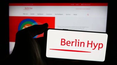Stuttgart, Almanya - 07-21-2024: Alman mortgage bankacılık şirketi Berlin Hyp AG 'nin logosuna sahip akıllı telefon sahibi kişi web sitesi önünde. Telefon ekranına odaklan.