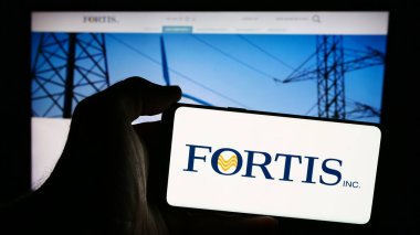 Stuttgart, Almanya - 07-23-2024: Kanadalı elektrik şirketi Fortis Inc. 'in logosunu taşıyan cep telefonu sahibi kişi iş sayfasının önünde. Telefon ekranına odaklan.