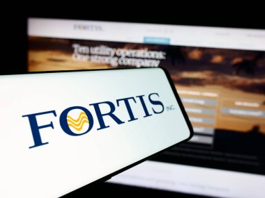 Stuttgart, Germany - 07-23-2024: Smartphone with logo of Canadian electric utility company Fortis Inc. in front of business website. Focus on center-left of phone display. clipart