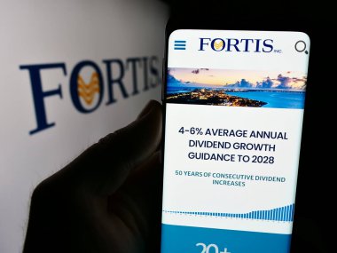 Stuttgart, Almanya - 07-23-2024: Kanadalı elektrik şirketi Fortis Inc. 'in internet sayfası ile logo önünde cep telefonu tutan kişi. Telefon ekranının merkezine odaklan.