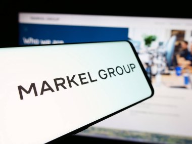 Stuttgart, Germany - 07-23-2024: Mobile phone with logo of American financial services company Markel Group Inc. in front of website. Focus on center-left of phone display. clipart