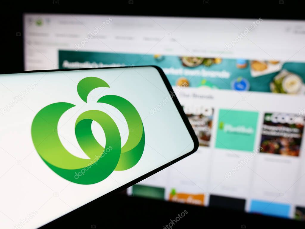 Stuttgart, Germany - 07-21-2024: Mobile phone with logo of Australian retail chain company Woolworths Supermarkets in front of business website. Focus on center of phone display.