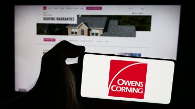Stuttgart, Almanya - 07-24-2024: ABD 'li inşaat malzemeleri şirketi Owens Corning' in logosunun bulunduğu akıllı telefon sahibi kişi web sitesi önünde. Telefon ekranına odaklan.