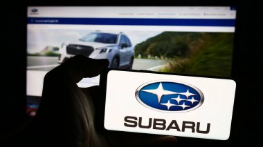 Stuttgart, Almanya - 07-25-2024: Japon şirketi Subaru Corporation 'ın logosunun bulunduğu akıllı telefon sahibi kişi web sitesi önünde. Telefon ekranına odaklan.
