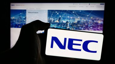 Stuttgart, Almanya - 07-25-2024: Japon bilgi teknolojileri şirketi NEC Corporation 'ın logosunun bulunduğu cep telefonu web sayfasının önünde duruyor. Telefon ekranına odaklan.