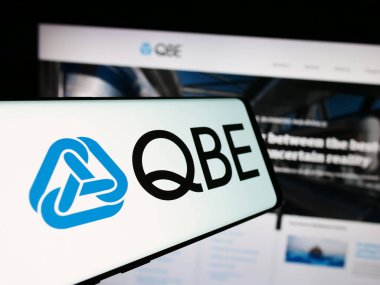 Stuttgart, Almanya - 07-25-2024: Avustralyalı QBE Sigorta Group Limited şirketinin logosuna sahip akıllı telefon şirket web sitesi önünde. Telefon ekranının merkezine odaklan.