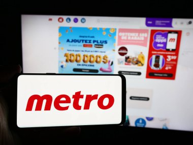 Stuttgart, Almanya - 07-29-2024: İnternet sitesi önünde Kanadalı perakende şirketi Metro Inc. 'in logosuna sahip kişi. Telefon ekranına odaklan.