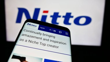 Stuttgart, Almanya - 07-29-2024: Japon kimya şirketi Nitto Denko Corporation 'ın web sitesi ile birlikte iş logosu önünde cep telefonu. Telefon ekranının sol üst kısmına odaklan.
