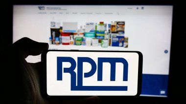 Stuttgart, Almanya - 07-29-2024: ABD 'li kaplama şirketi RPM International Inc.' in logosuyla cep telefonu sahibi kişi iş sayfasının önünde. Telefon ekranına odaklan.