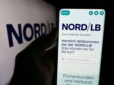Stuttgart, Almanya - 07-30-2024: Alman Norddeutsche Landesbank (Nord LB) şirketinin logosuna sahip cep telefonu sahibi kişi iş sayfası önünde. Telefon ekranına odaklan.