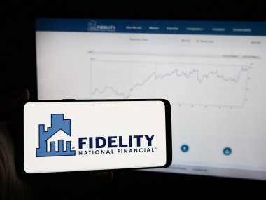 Stuttgart, Almanya - 07-30-2024: İnternet sayfasının önünde Amerikan finans şirketi Fidelity National Financial Inc. 'in logosu olan cep telefonu sahibi kişi. Telefon ekranına odaklan.