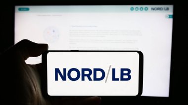 Stuttgart, Almanya - 07-30-2024: Alman Norddeutsche Landesbank (Nord LB) şirketinin logosuna sahip cep telefonu sahibi kişi iş sayfası önünde. Telefon ekranına odaklan.