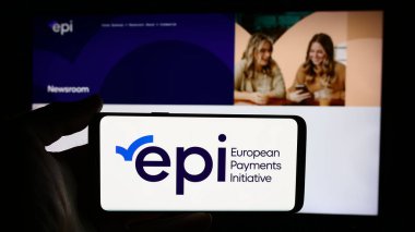 Stuttgart, Almanya - 07-31-2024: Avrupa Ödemeler Girişimi 'nin (EPI) logosuna sahip cep telefonu sahibi kişi iş sayfası önünde. Telefon ekranına odaklan.