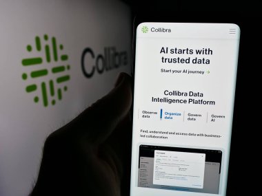 Stuttgart, Almanya - 08-09-2024: Veri istihbarat şirketi Collibra Belçika BV 'nin web sayfası ile logo önünde cep telefonu tutan kişi. Telefon ekranının merkezine odaklan.