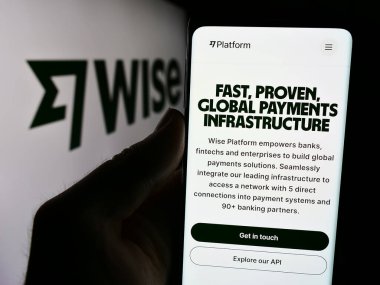 Stuttgart, Almanya - 08-09-2024: İngiliz finans şirketi Wise plc 'in web sayfası ile logo önünde cep telefonu tutan kişi. Telefon ekranının merkezine odaklan.