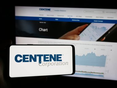 Stuttgart, Almanya - 08-12-2024: Amerikan özel bakım şirketi Centene Corporation 'ın logosunun bulunduğu cep telefonu sahibi kişi iş sayfasının önünde. Telefon ekranına odaklan.