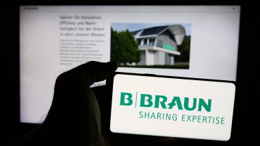 Stuttgart, Almanya - 08-01-2024: Alman otomotiv şirketi Ebersaepcher Gruppe GmbH Co. KG 'nin logosuna sahip cep telefonu sahibi kişi web sayfasının önünde. Telefon ekranına odaklan.