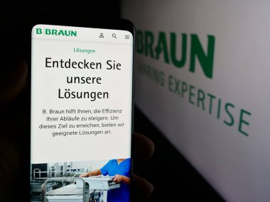 Stuttgart, Almanya - 08-01-2024: Alman otomotiv şirketi Ebersaepcher Gruppe GmbH Co. KG 'nin logosuna sahip cep telefonu sahibi kişi web sayfasının önünde. Telefon ekranına odaklan.