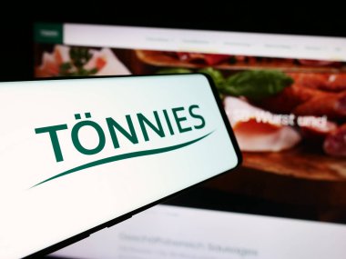 Stuttgart, Almanya - 08-01-2024: Alman Toennies şirketinin logosunu web sayfasının önünde tutan kişi. Telefon ekranına odaklan.