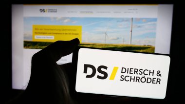 Stuttgart, Almanya - 08-01-2024: Alman Diersch ve Schroeder şirketlerinin logosunun bulunduğu cep telefonu sahibi kişi web sayfasının önünde. Telefon ekranına odaklan.