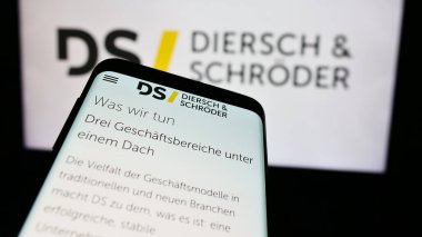 Stuttgart, Almanya - 08-01-2024: Alman Diersch ve Schroeder GmbH Co. KG şirketlerinin internet sayfası ile akıllı telefon sahibi kişi logonun önünde. Telefon ekranının merkezine odaklan.