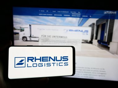Stuttgart, Almanya - 08-01-2024: Alman lojistik şirketi Rhenus SE Co. KG 'nin logosuna sahip akıllı telefon sahibi kişi web sitesinin önünde. Telefon ekranına odaklan.