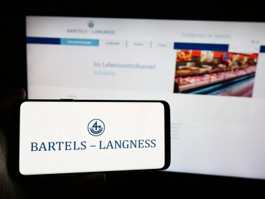 Stuttgart, Almanya - 08-02-2024: İnternet sayfasının önünde Bartels-Langness Handelsgesellschaft mbH Co. KG şirketinin logosuna sahip cep telefonu sahibi kişi. Telefon ekranına odaklan.