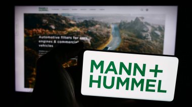 Stuttgart, Almanya - 08-05-2024: Alman şirketi Mann Hummel International GmbH Co. KG 'nin logosuna sahip akıllı telefon sahibi kişi web sitesi önünde. Telefon ekranına odaklan.