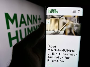 Stuttgart, Almanya - 08-05-2024: Alman şirketi Mann Hummel International GmbH Co. KG 'nin web sitesi ile akıllı telefon sahibi kişi logonun önünde. Telefon ekranının merkezine odaklan.