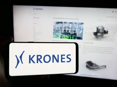 Stuttgart, Almanya - 08-05-2024: Alman mühendislik şirketi Krones AG 'nin logosunun bulunduğu akıllı telefonu web sitesinin önünde tutan kişi. Telefon ekranına odaklan.