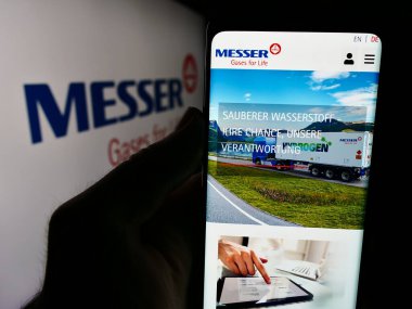 Stuttgart, Almanya - 08-05-2024: Alman endüstriyel gaz şirketi Messer SE Co. KGaA 'nın web sitesi ile logo önünde cep telefonu tutan kişi. Telefon ekranının merkezine odaklan.