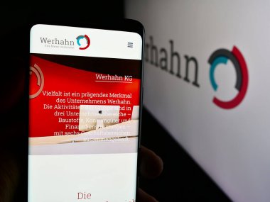 Stuttgart, Almanya - 08-05-2024: Alman holdingi Wilh 'in web sayfası ile cep telefonu tutan kişi. Werhahn KG logonun önünde. Telefon ekranının merkezine odaklan.