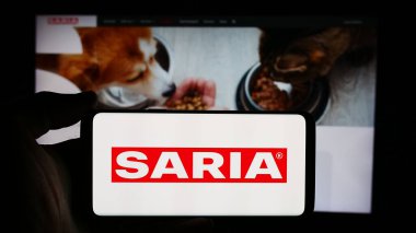 Stuttgart, Almanya - 08-06-2024: Alman gıda şirketi Saria AS GmbH Co. KG 'nin logosuyla cep telefonu tutan kişi iş sayfasının önünde. Telefon ekranına odaklan.