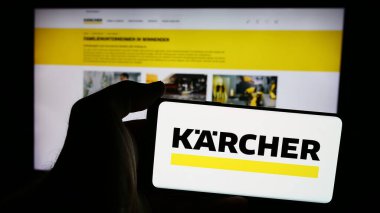 Stuttgart, Almanya - 08-07-2024: Alman temizlik araçları şirketi Alfred Kaercher SE Co. KG 'nin logolu web sayfası ile cep telefonu tutan kişi. Telefon ekranının merkezine odaklan.