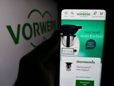 Stuttgart, Almanya - 08-07-2024: Alman ev aletleri şirketi Vorwerk SE Co. KG 'nin internet sayfası ile logo önünde cep telefonu tutan kişi. Telefon ekranının merkezine odaklan.