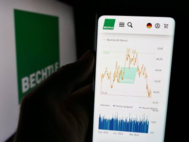 Stuttgart, Almanya - 08-07-2024: Alman bilgi teknolojileri şirketi Bechtle AG 'nin internet sayfası ile logo önünde cep telefonu tutan kişi. Telefon ekranının merkezine odaklan.
