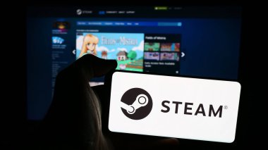 Stuttgart, Almanya - 08-08-2024: İnternet sayfası önünde üzerinde Amerikan video oyunu dağıtım şirketi Steam 'in logosu olan cep telefonu bulunduran kişi. Telefon ekranına odaklan.