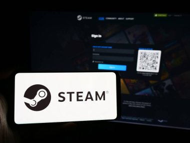 Stuttgart, Almanya - 08-08-2024: İnternet sitesinin önünde ABD 'li video oyunu dağıtım şirketi Steam' in (Valf) logosuna sahip kişi. Telefon ekranına odaklan.